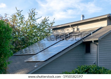 Solar photovoltaic panels on a slanted roof in the Pacific Northwest. Royalty-Free Stock Photo #1950182197
