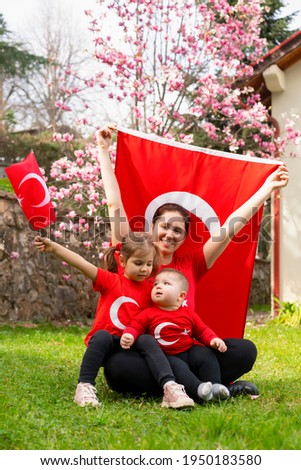 Portrait of little kids with mother. Cute babies with Turkish flag t-shirt. Toddlers and mom hold Turkish flag in hand. Copy space for text.
