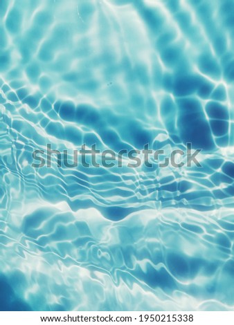Abstract​ of​ surface​ blue​ water​ in​ the​ swimming​ pool​ for​ background. Reflection​ of​ surface​ blue​ water​ in​ the​ sea. Closeup blur​ abstract​ for​ graphic​ design.