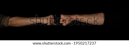 Man and woman fist to fist isolated on the black background. Panoramic shot. Copy space for text message. Panorama banner.