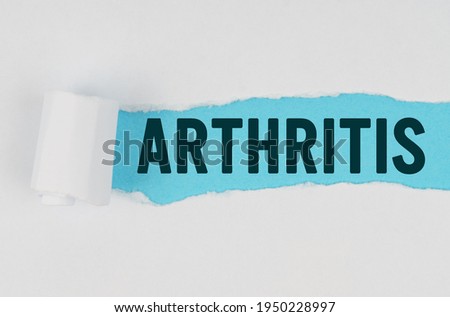 Medicine and health concept. In the middle of a white sheet of paper, a tear is made under which, on a blue background, the inscription - ARTHRITIS