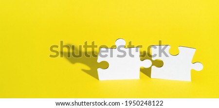 Connect couple puzzle piece on yellow background. Symbol of association and connection, business strategy, completing, team support and help concept. Two wooden puzzles stand almost together. Artwork