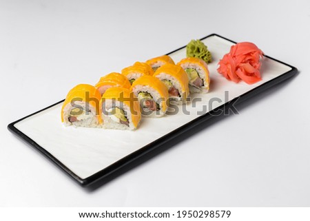 Sushi Rolls with processed cheese cheddar, american cheese, avocado, tuna and cream cheese inside on white slate on white background. Philadelphia roll sushi. Sushi menu