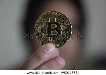 A woman showing her golden Bitcoin 