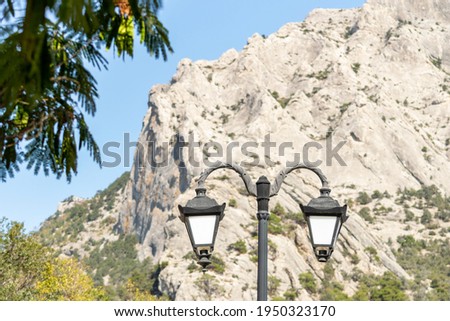Street lantern against the background of the rock. Sunny autumn day. Front view.