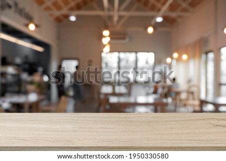 Empty wooden desk with blur background of cafe and restaurant. For montage products.