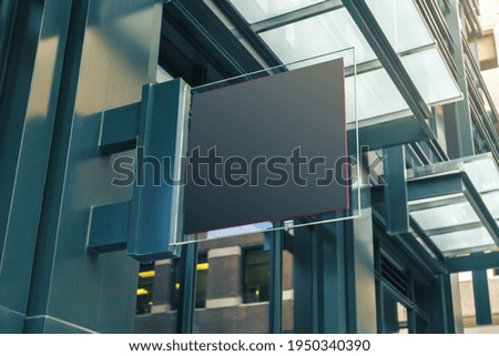 Black square signboard on the wall of a modern business center, mock up