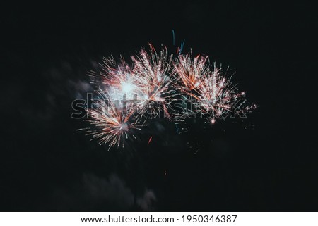 Festive salute or firecrackers on night sky. Explosions of fireworks and pyrotechnics in the sky.