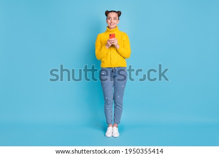 Full size photo of charming cheerful girl look interested empty space toothy smile isolated on blue color background