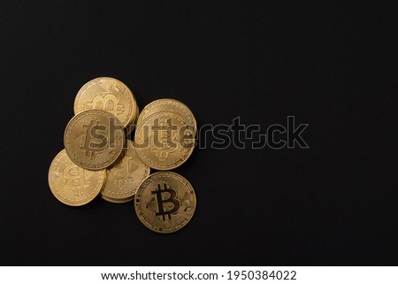 Set of golden bitcoins on black background.