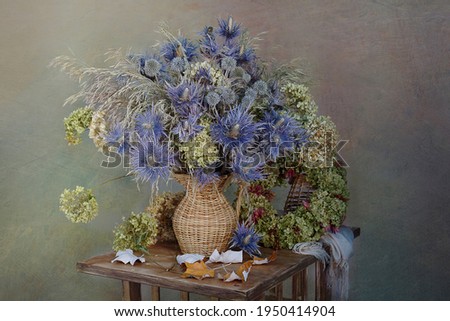 Dry flowers and herbs, leaves. Still life of dried flowers and herbs in a wicker vase.