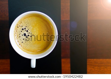 Close up a cup of black aroma coffee with chilling morning mood on wooden table at home. Top view image.                                   