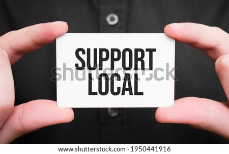 Businessman holding a card with text support local,business concept
