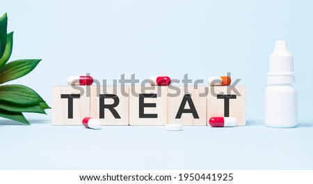 TREAT word made with building blocks. A row of wooden cubes with a word written in black font is located on white background