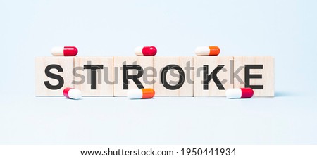 STROKE word made on wooden cube blocks and flower in a pot on background. Health and medicine concept. Healthcare concept.