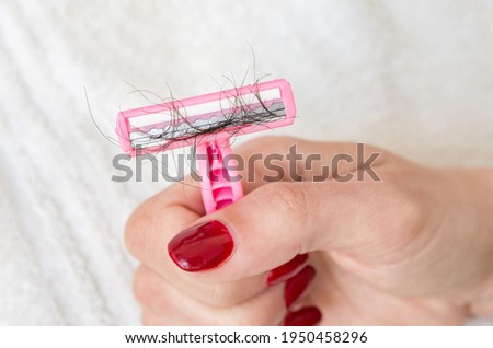 Women's shaving razor with shaved off unwanted pubic hairs
