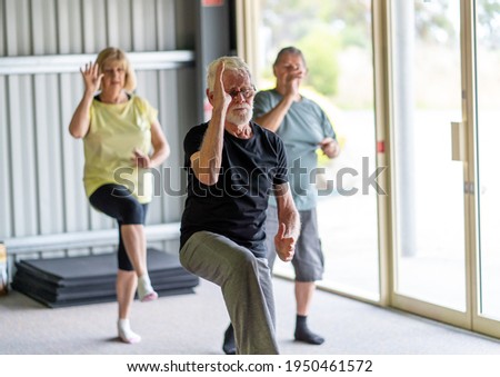 Group of seniors in Tai Chi class exercising in an active retirement lifestyle. Mental and physical health benefits of exercise and fitness in elderly people. Senior health care and wellbeing concept. Royalty-Free Stock Photo #1950461572