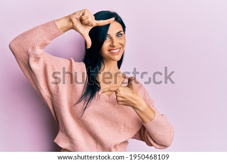 Young caucasian woman wearing casual clothes smiling making frame with hands and fingers with happy face. creativity and photography concept. 