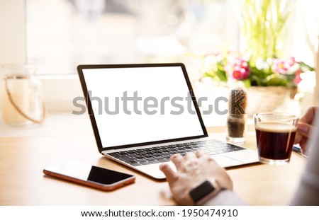 Woman working with laptop computer, mockup with empty blank screen Royalty-Free Stock Photo #1950474910