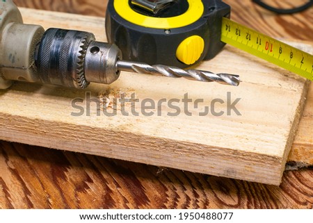 measuring tape and electric drill with drill on board concept repair construction. High quality photo