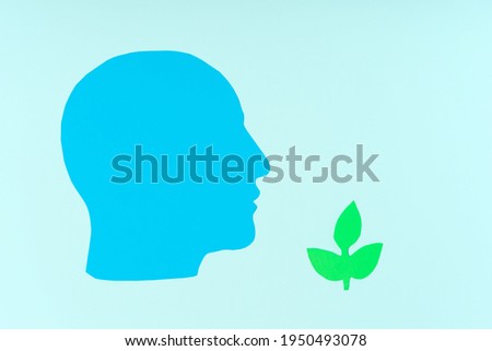 Paper head and carved green plant. The concept of ecology, restoration of natural resources, eco