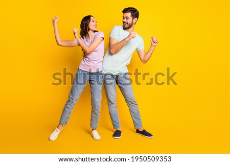 Full length body size view of lovely funny cheerful couple dancing having fun fooling isolated over bright yellow color background
