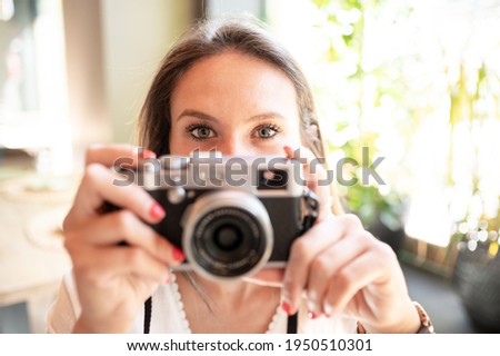 Young girl with pretty eyes holding a vintage camera in her hands