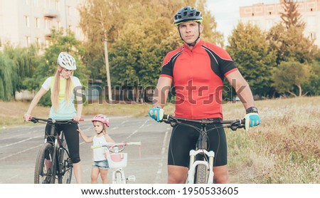 sports family ride bicycles in the city at the stadium