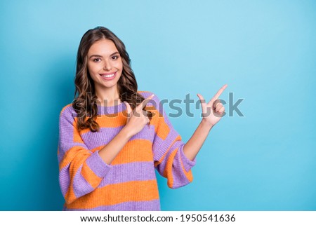 Photo of attractive cheerful young nice lady point index fingers empty space promo isolated on blue color background