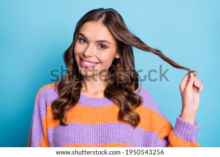 Photo of lovely flirty lady play curl look camera shiny white smile wear striped sweater isolated blue background