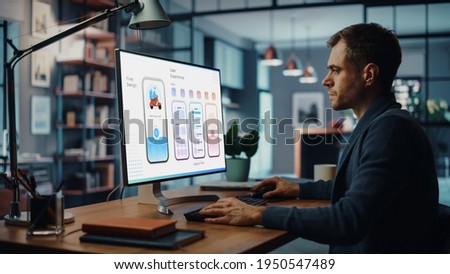 Handsome Caucasian Male Designer Working on Desktop Computer in Creative Living Room. Freelance Male is Developing New Food Delivery App Design, User interface in a Digital Graphics Editing Software. Royalty-Free Stock Photo #1950547489