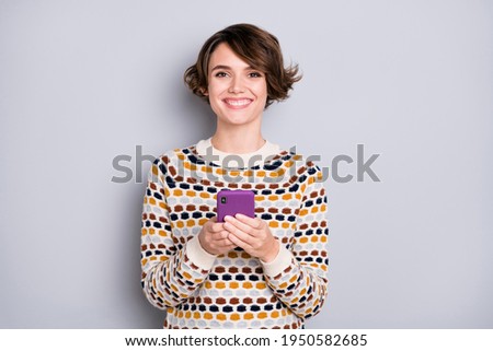 Portrait of lovely cheerful girl using device chatting smm post media isolated over grey pastel color background