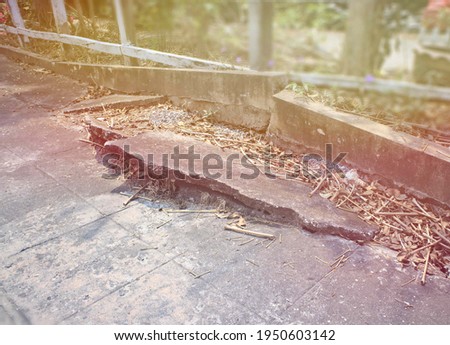 Broken concrete footpaths, black floor, old pavement, fallen leaves