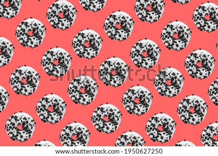 Pattern made with black and white cookie donut on red background