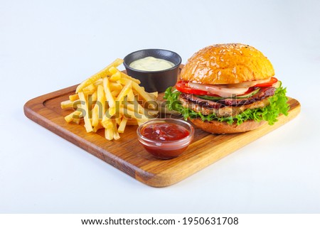 juicy hamburger on a white plate in the studio Royalty-Free Stock Photo #1950631708