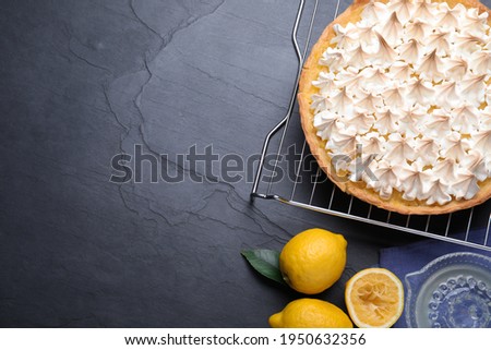 Flat lay composition with delicious lemon meringue pie on black table. Space for text