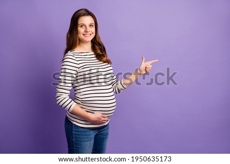 Photo of pretty cute lady waiting baby dressed striped shirt arm tummy pointing empty space isolated violet color background