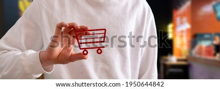 a person holding a shopping cart icon, concept of online shopping market, sale and purchase
