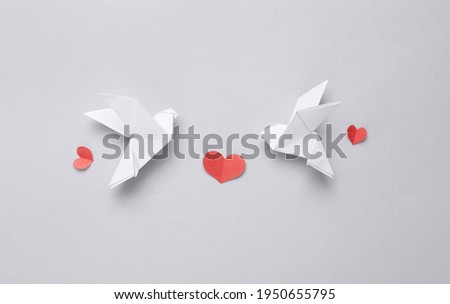 Peace symbol. Origami doves birds and paper cut hearts on gray background