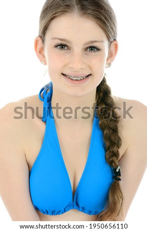 Portrait of a beautiful teenage girl wearing a blue bikini top in studio isolated on white