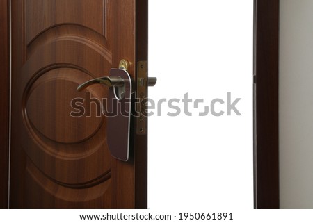 Hotel wooden door with blank hanger on white background, closeup