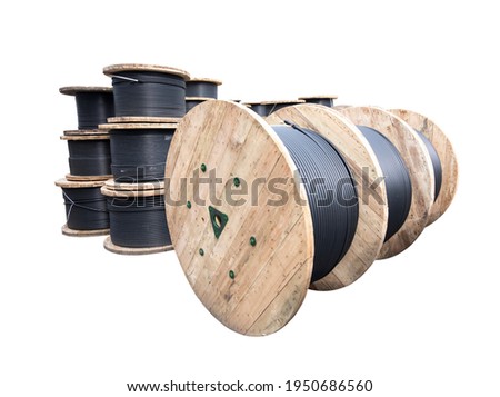 Wooden Coils Of Electric Cable Outdoor. High and low voltage cables on white background. Royalty-Free Stock Photo #1950686560