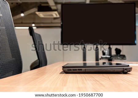 Laptop on table with television display blank background