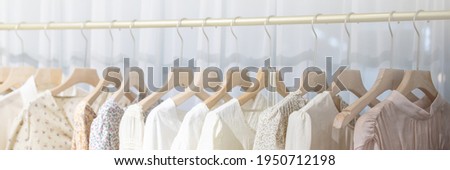 Row of different female clothes hanging on rack in hipster fashion show room in shopping mall. Trendy women wear Royalty-Free Stock Photo #1950712198