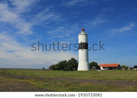Lighthouse, Lange Jan (Långe Jan) on the coast side with a blue sky and open field in front, Öland, Sweden