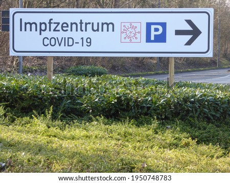 Signpost sign "Impfzentrum Covid-19" translates to "Covid-19 vaccination center". Signposting of the parking lot. Location: Hürthpark, Germany . Pandemy Corona Info sign parking lot in pandemy .
