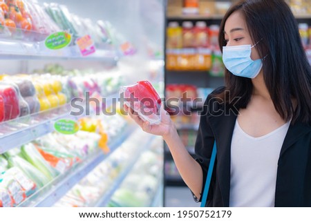 Beautiful asian woman walking shopping in a supermarket,Time for relax,Buy for dinner,Thailand people,Happy time lifestyle concept,Stock up on covid-19