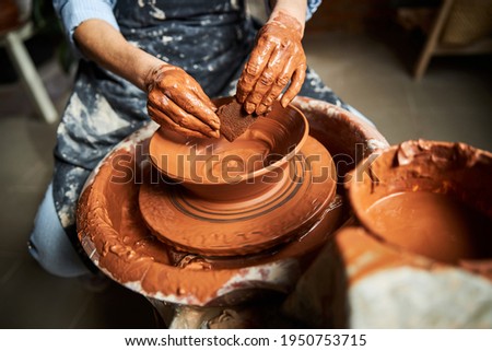 Senior woman hands making clay pot in pottery studio