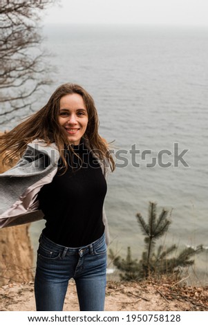 beautiful girl dressed in a gray coat on the background of the Baltic Sea