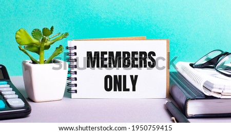MEMBERS ONLY is written on a white card next to a potted flower, diaries and calculator. Organizational concept